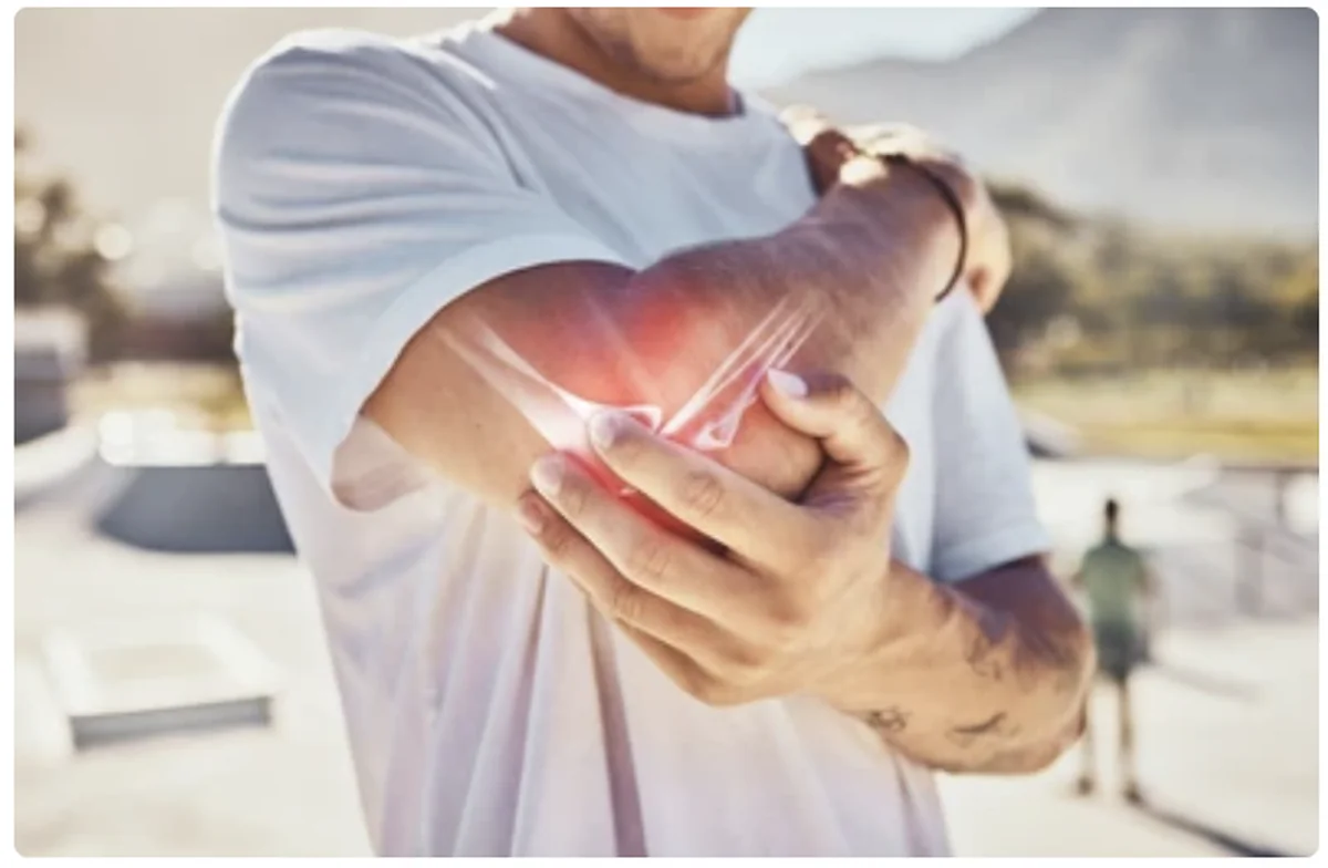 Active man holding his elbow while outdoors, illustrating joint discomfort